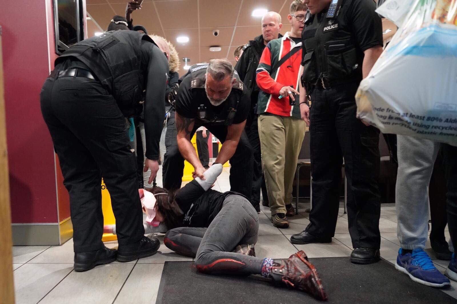 Image may contain: Crowd, Police, People, Pants, Apparel, Clothing, Shoe, Footwear, Human, Person