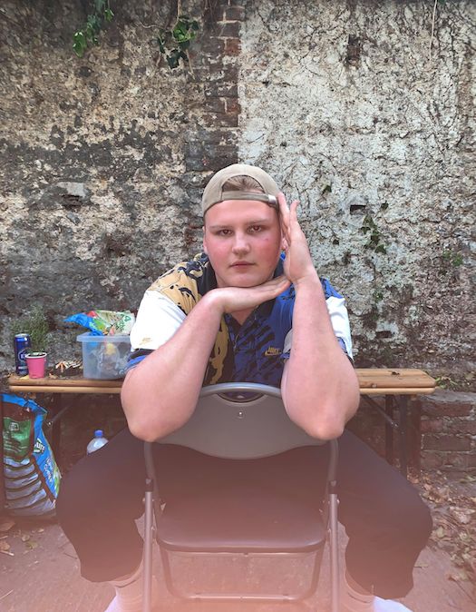 Image may contain: Portrait, Photography, Photo, Outdoors, Wood, Table, Sitting, Face, Human, Person, Apparel, Clothing, Furniture, Chair