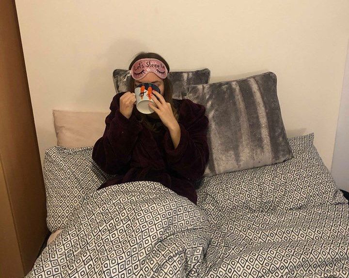 Image may contain: Bed, Camera, Electronics, Couch, Person, Human, Furniture