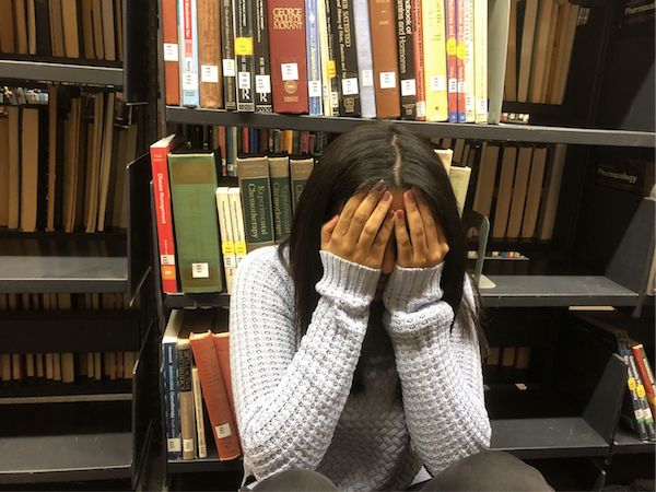 Image may contain: Shelf, Bookcase, Person, Human, Furniture, Book, Library, Indoors, Room