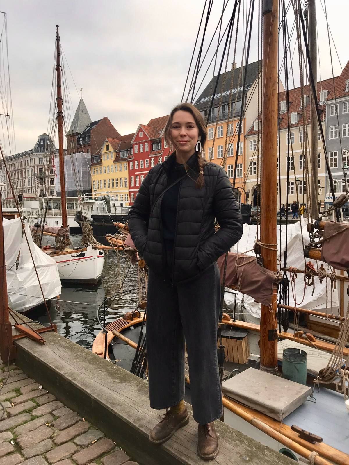 Image may contain: Building, City, Metropolis, Town, Urban, Wood, Marina, Boat, Coat, Overcoat, Pier, Port, Dock, Human, Person, Waterfront, Water, Watercraft, Vessel, Transportation, Vehicle, Apparel, Clothing