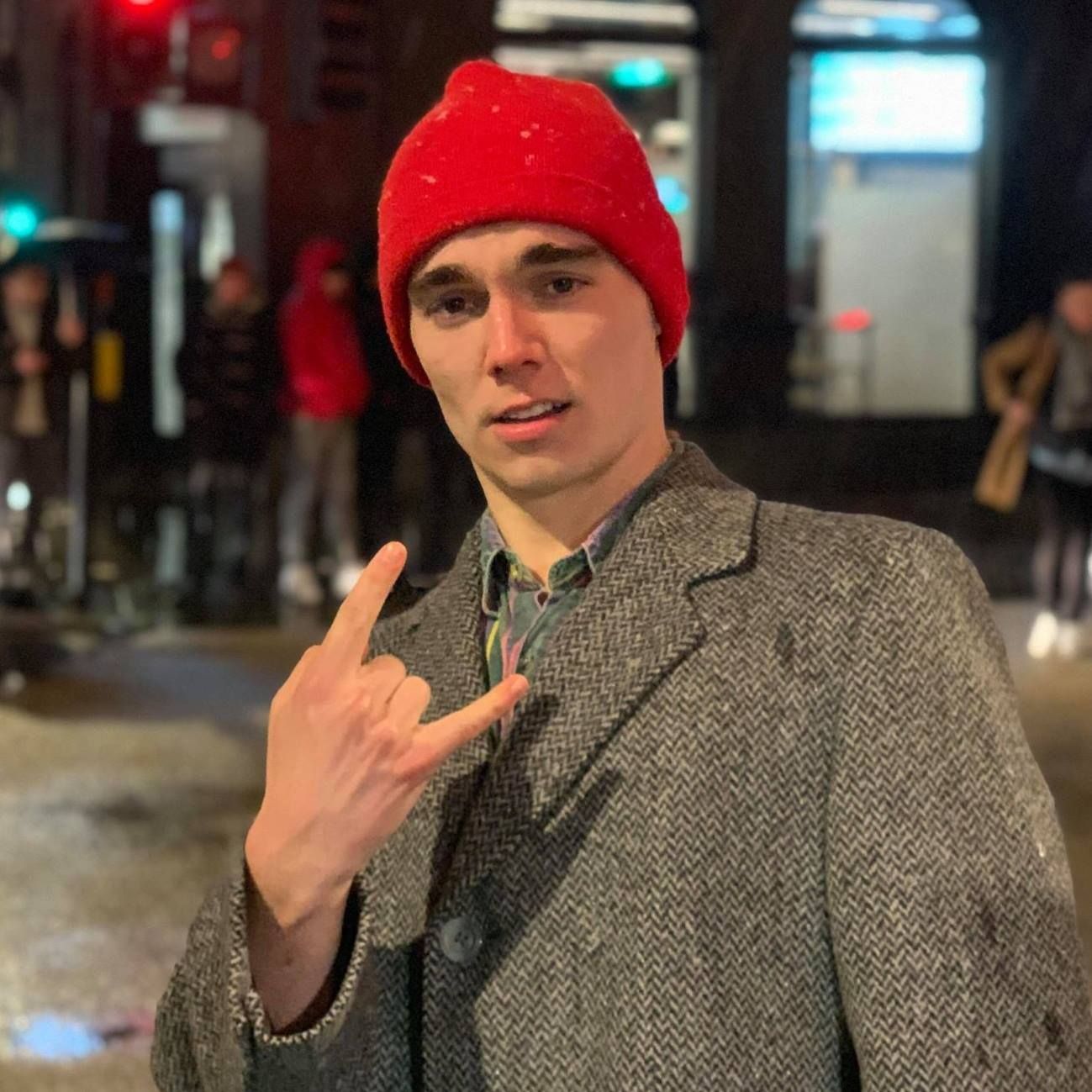 Image may contain: Overcoat, Coat, Cap, Beanie, Hat, Person, Human, Apparel, Clothing