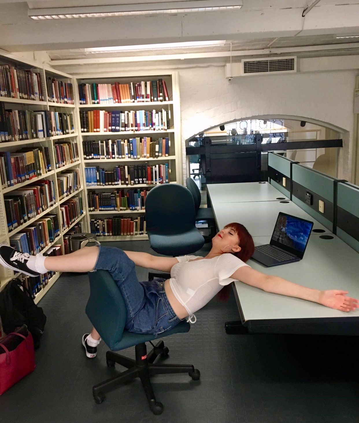 Image may contain: Electronics, Pc, Computer, Laptop, Apparel, Clothing, Shoe, Footwear, Book, Library, Bookcase, Shelf, Room, Human, Person, Indoors, Furniture