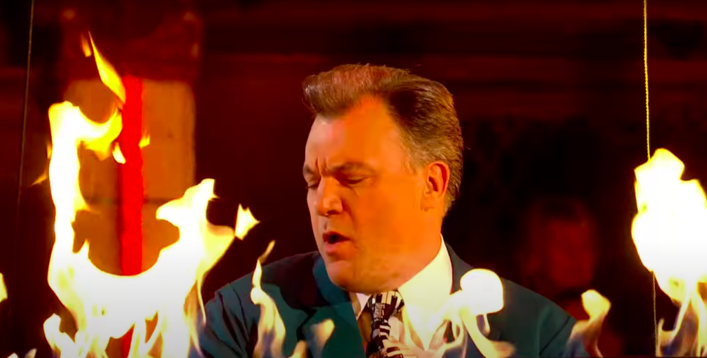 Balls playing a piano with flames behind him