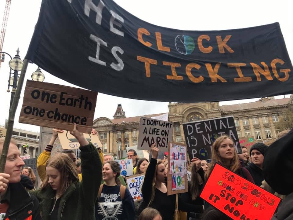 Image may contain: Parade, Crowd, Banner, Text, Human, Person