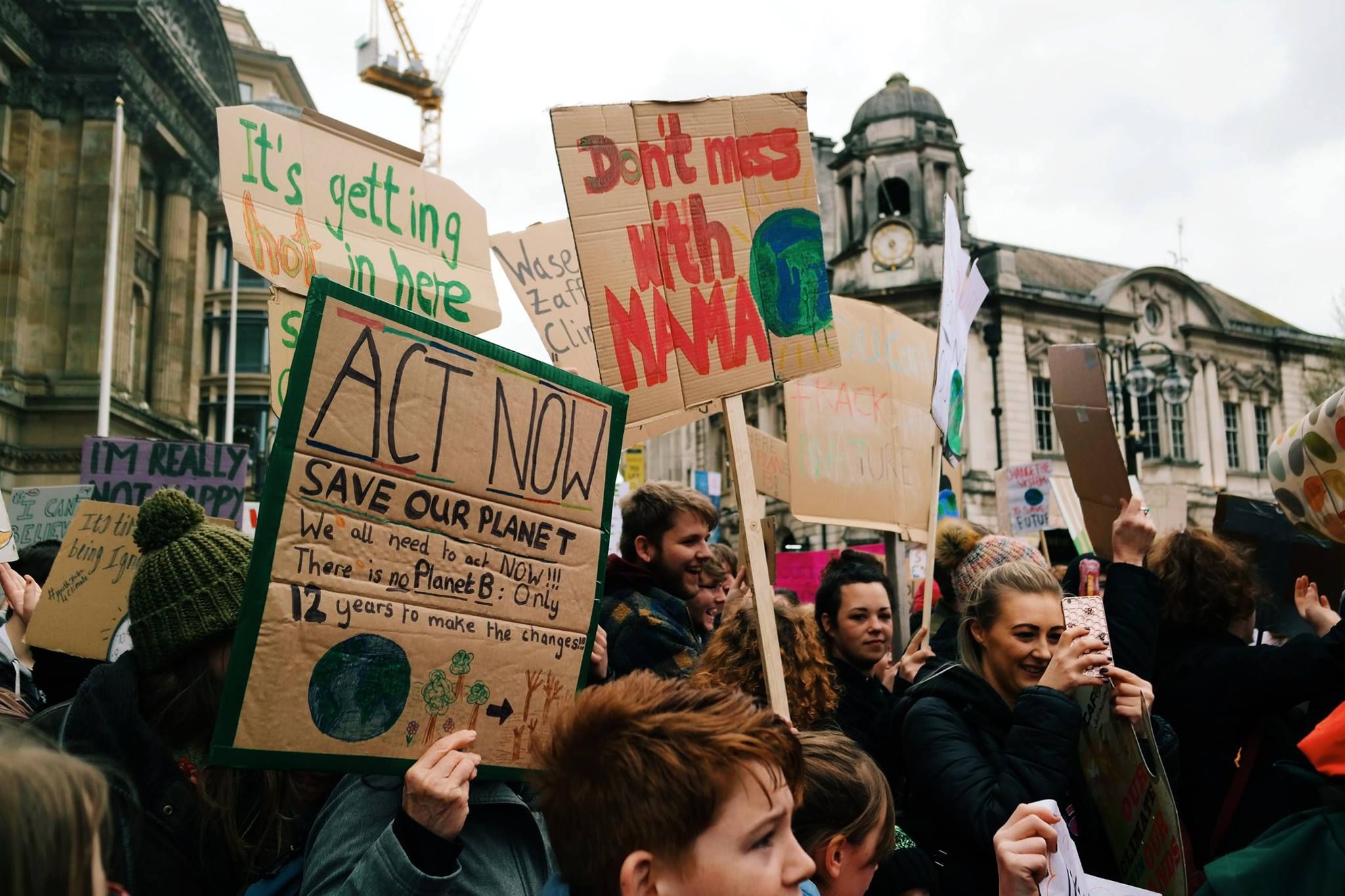 Image may contain: People, Protest, Parade, Building, Tower, Architecture, Clock Tower, Banner, Crowd, Text, Person, Human