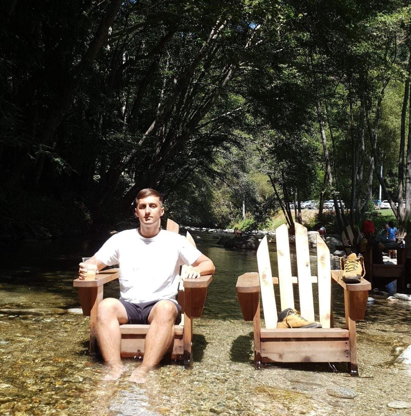 Image may contain: Plant, Tree, Plywood, Shorts, Clothing, Apparel, Sitting, Furniture, Chair, Person, Human, Wood