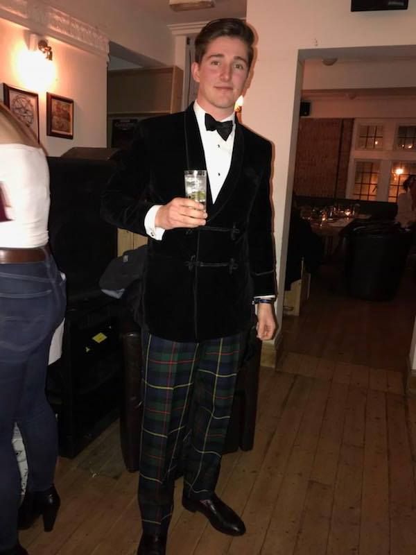 Image may contain: Tuxedo, Suit, Overcoat, Coat, Clothing, Tartan, Plaid, Person, People, Human