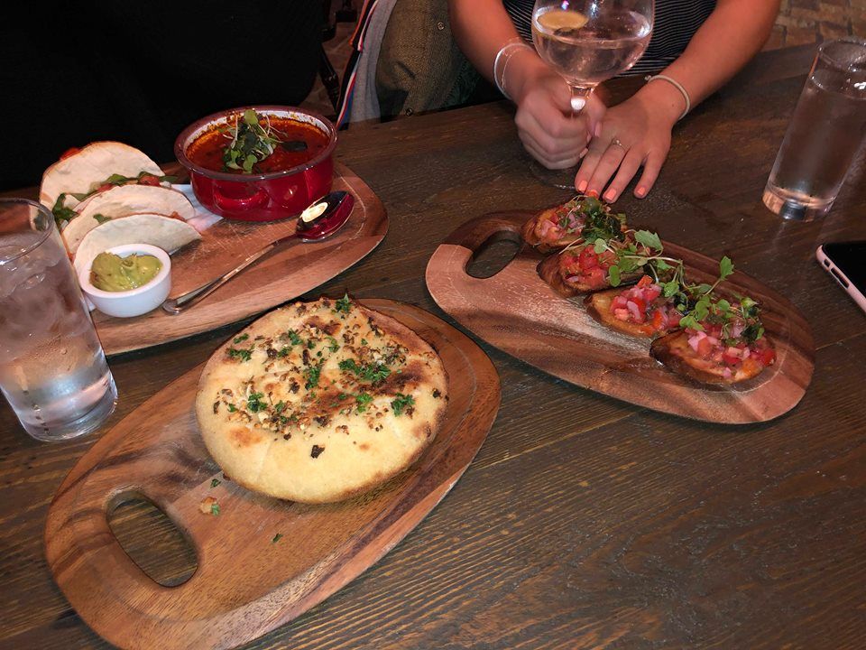 Image may contain: Glass, Dish, Meal, Dining Table, Furniture, Table, Bread, Human, Person, Pizza, Food