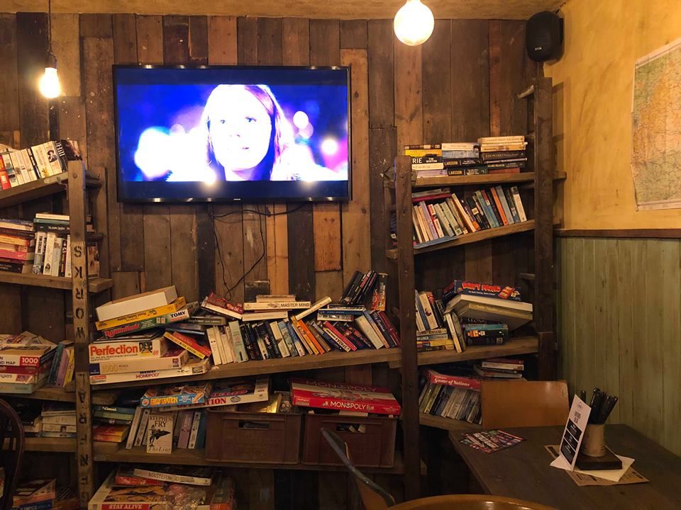 Image may contain: Person, Human, Room, Entertainment Center, Television, TV, LCD Screen, Bookcase, Shelf, Interior Design, Indoors, Furniture, Screen, Display, Monitor, Electronics