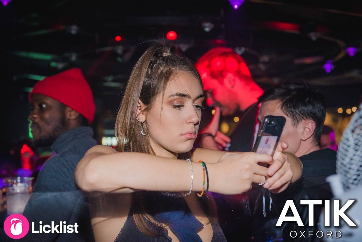 Image may contain: Disco, Hat, Clothing, Apparel, Party, Night Life, Electronics, Cell Phone, Phone, Mobile Phone, Night Club, Club, Human, Person