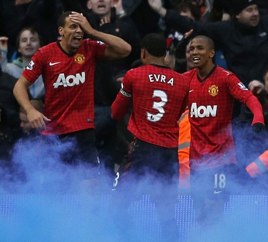 Manchester United's Ferdinand reacts as his head is cut by an object thrown from the crowd during their English Premier League soccer match in Manchester