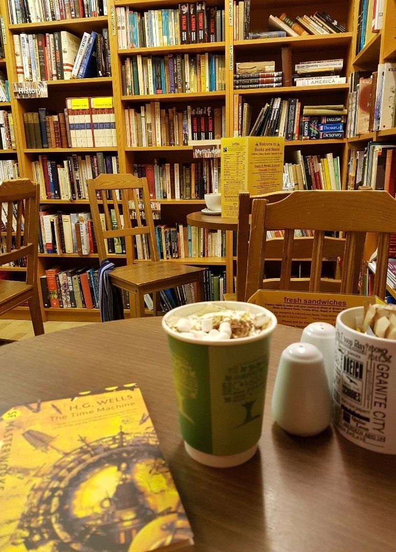 Image may contain: Coffee Cup, Cup, Library, Bookstore, Shop, Book, Chair, Bookcase, Shelf, Room, Indoors, Furniture
