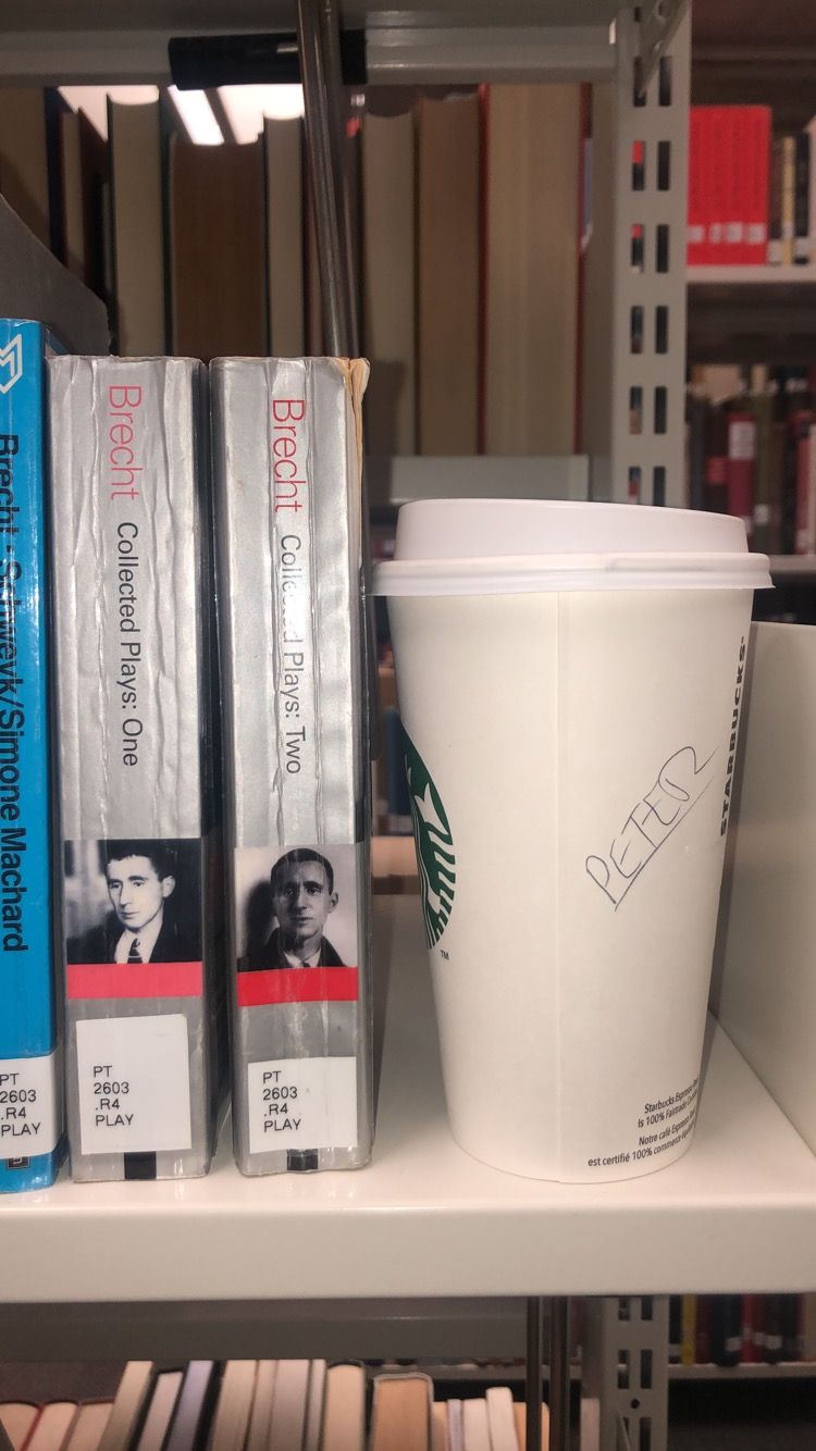 Image may contain: Bottle, Bookcase, Cup, Coffee Cup, Drink, Milk, Beverage, Person, Human, Shelf, Furniture, Book