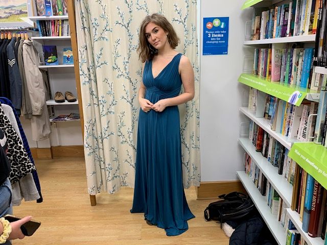 Image may contain: Woman, Interior Design, Bookcase, Female, Gown, Robe, Fashion, Evening Dress, Dress, Room, Indoors, Furniture, Person, Human, Shelf, Clothing, Apparel