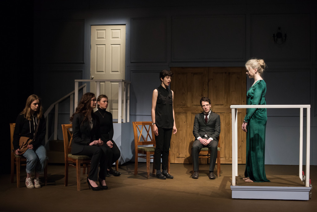Hermione (Ellen Gage) stands in the dock