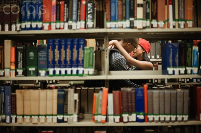 Couple kissing in library --- Image by © Troy House/Corbis