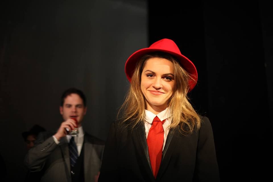 Image may contain: Speech, Stage, Play, Musical, Suit, Overcoat, Clothing, Person, People, Human