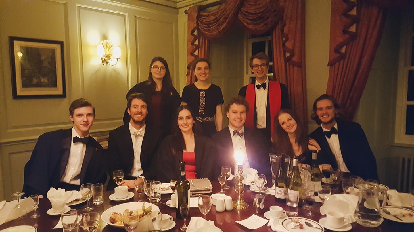 Image may contain: Supper, Meal, Food, Dinner, Restaurant, Waiting Room, Room, Reception Room, Reception, Indoors, Furniture, Tuxedo, Suit, Overcoat, Coat, Clothing, Person, People, Human