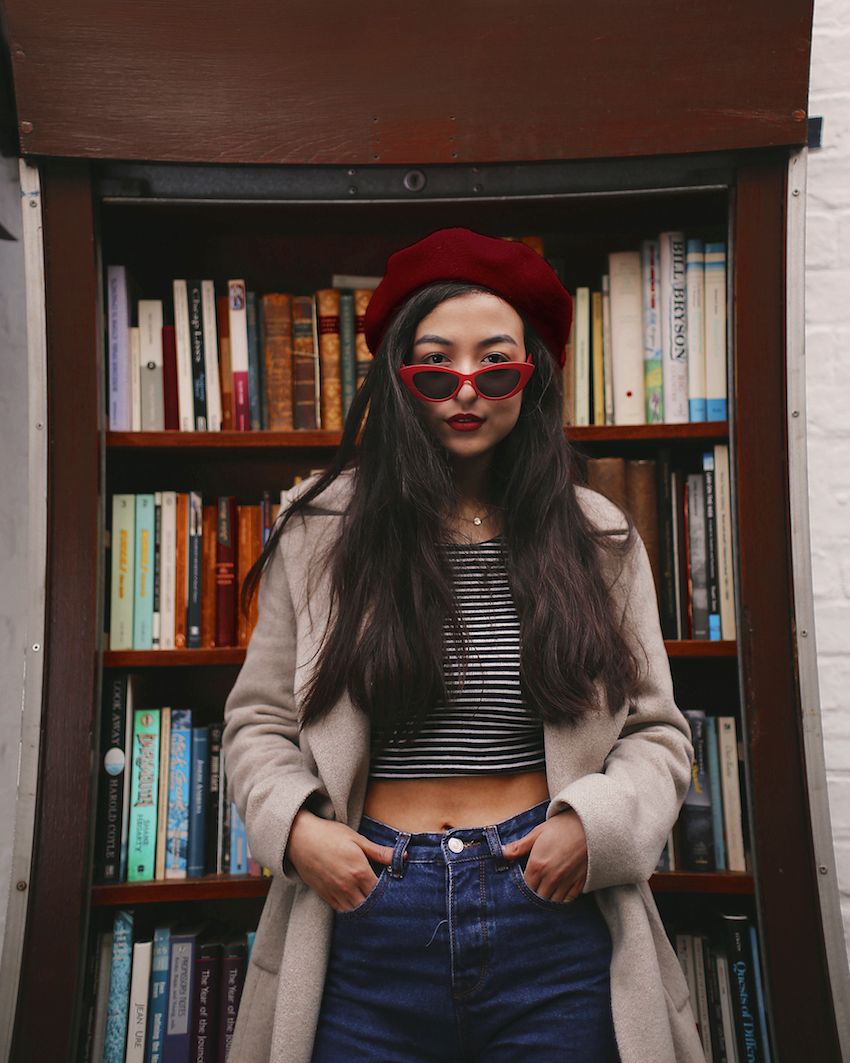 Image may contain: Indoors, Room, Clothing, Apparel, Accessory, Sunglasses, Accessories, Person, Human, Bookcase, Shelf, Furniture