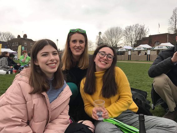 Image may contain: People, Smile, Crowd, Female, Plant, Grass, Sitting, Accessories, Sunglasses, Accessory, Clothing, Apparel, Face, Furniture, Chair, Human, Person