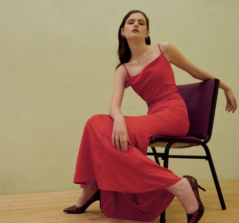 Image may contain: Flooring, Woman, Female, Dress, Shoe, Footwear, Evening Dress, Fashion, Robe, Gown, Person, Human, Chair, Furniture, Clothing, Apparel
