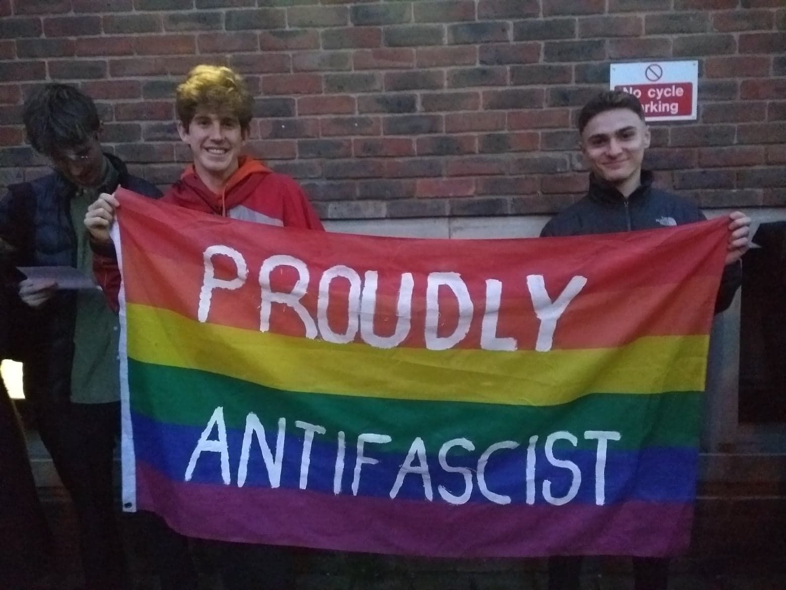 Image may contain: Banner, Symbol, Flag, Human, Person, Text
