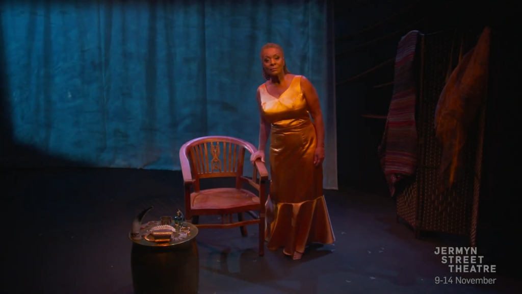 A screenshot from the trailer for the show, depicting a woman arising from her chair