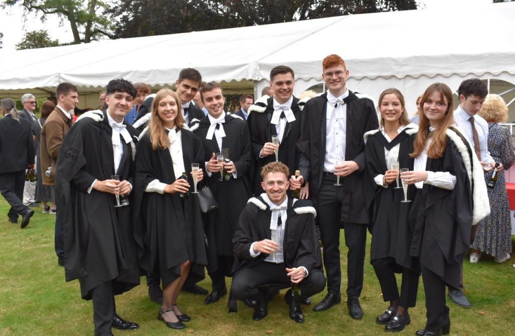 James in graduation gown with friends