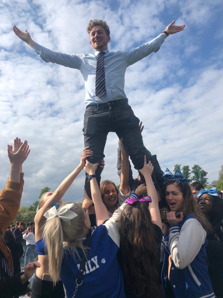 James in a cheerleader position, standing on people's hands