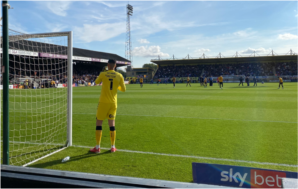 A goalkeeper stood on a football pitch