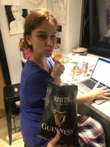 Lisa posing with a chip with the bag being held in the foreground.