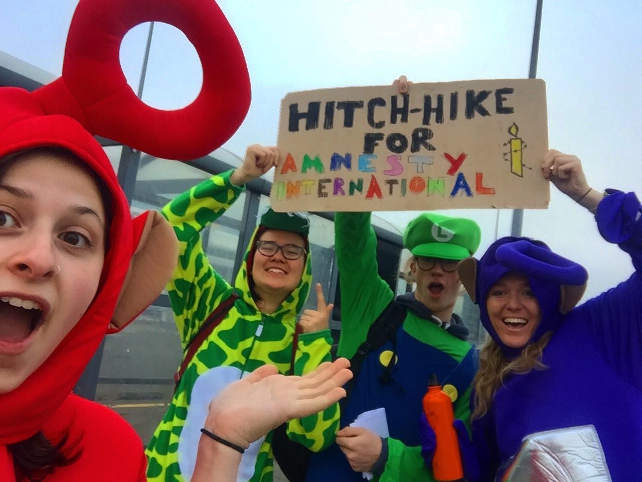 Image may contain: Portrait, Photo, Photography, People, Girl, Performer, Text, Hat, Word, Festival, Protest, Head, Smile, Apparel, Clothing, Female, Accessories, Glasses, Accessory, Costume, Parade, Face, Crowd, Human, Person