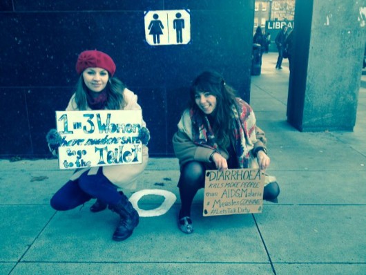Lynne Wham and Alice Owen from Water Aid doing some squatting practice.