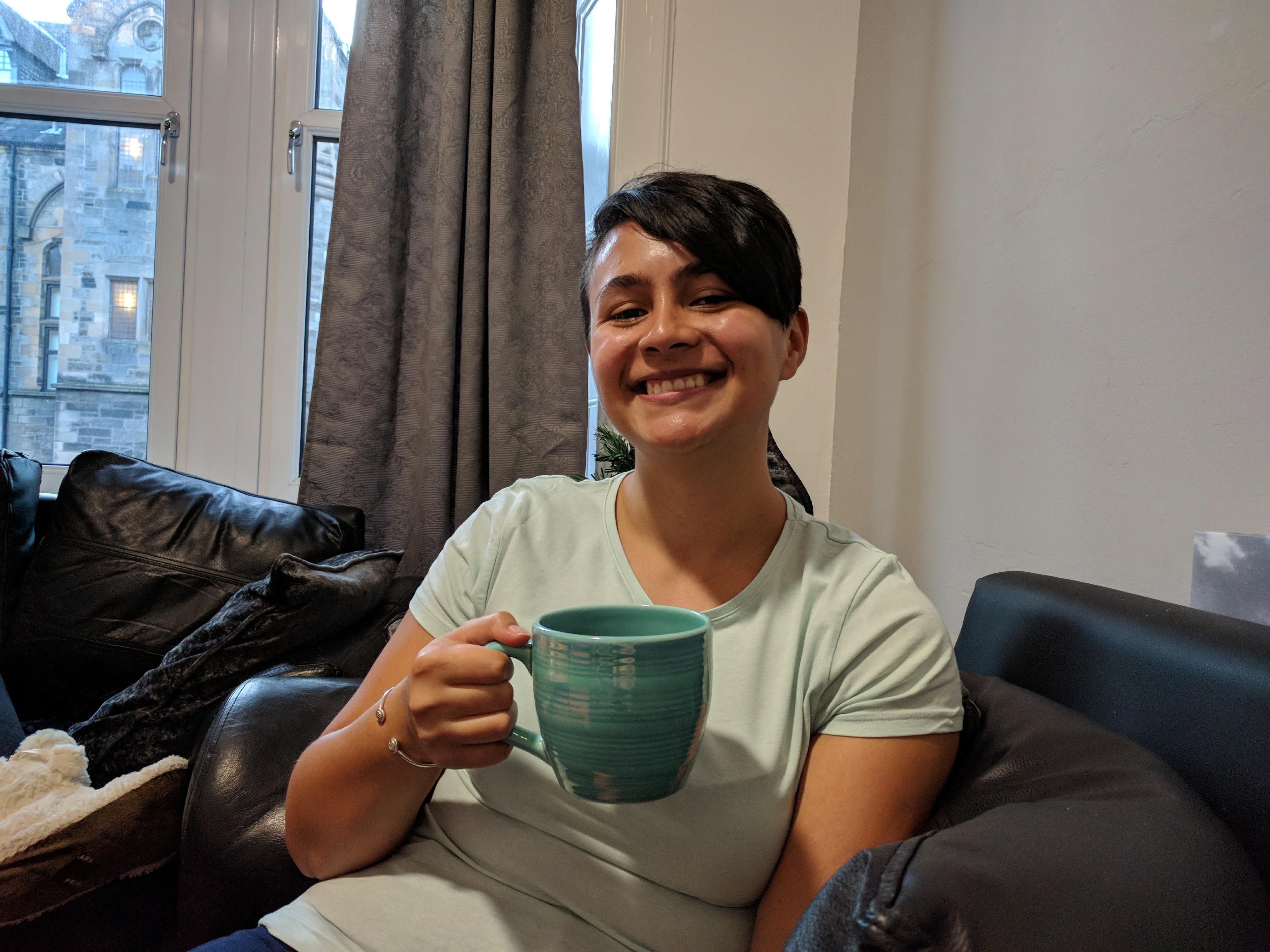 Image may contain: Cup, Coffee Cup, Furniture, Couch, Person, People, Human