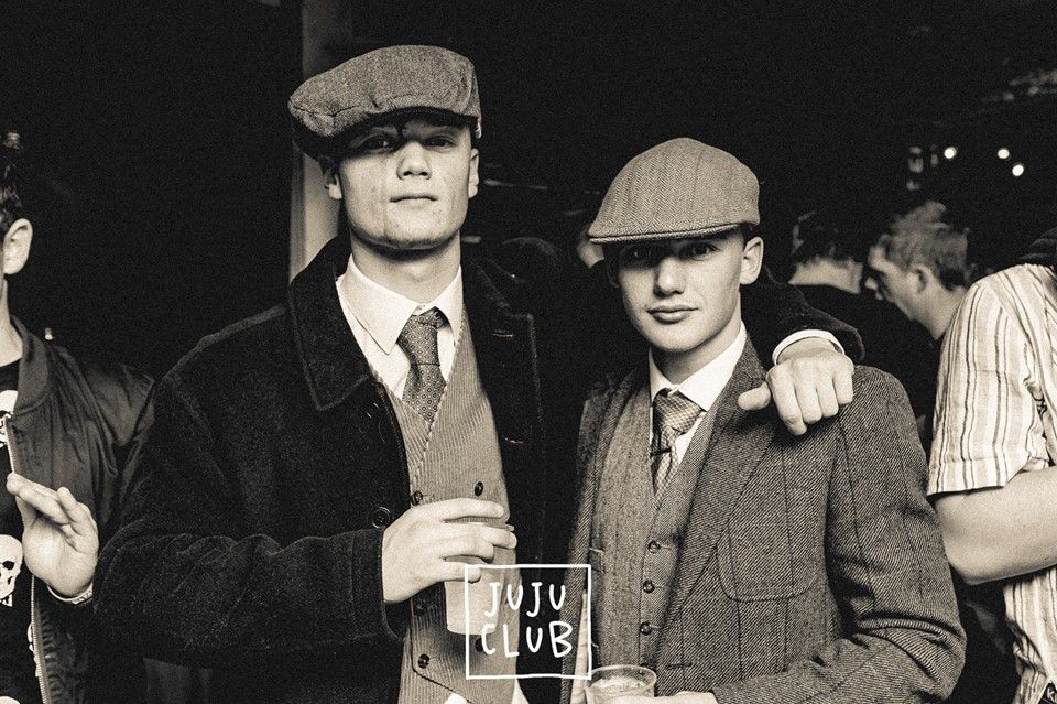 Image may contain: Beer, Alcohol, Drink, Beverage, Accessory, Accessories, Tie, Coat, Suit, Overcoat, Glass, Hat, Clothing, Apparel, Person, Human