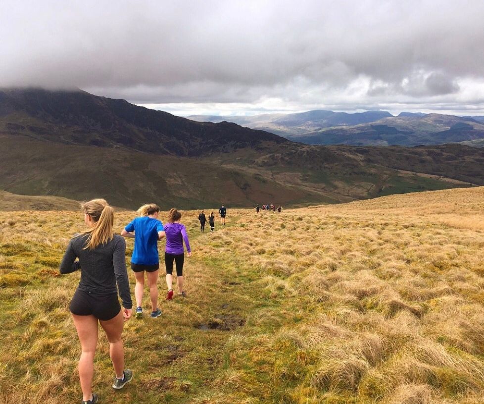 Image may contain: Mountain, Field, Wilderness, Countryside, Shoe, Footwear, Slope, Walking, Trail, Hiking, Nature, Path, Grass, Plant, Outdoors, Clothing, Apparel, Shorts, Human, Person