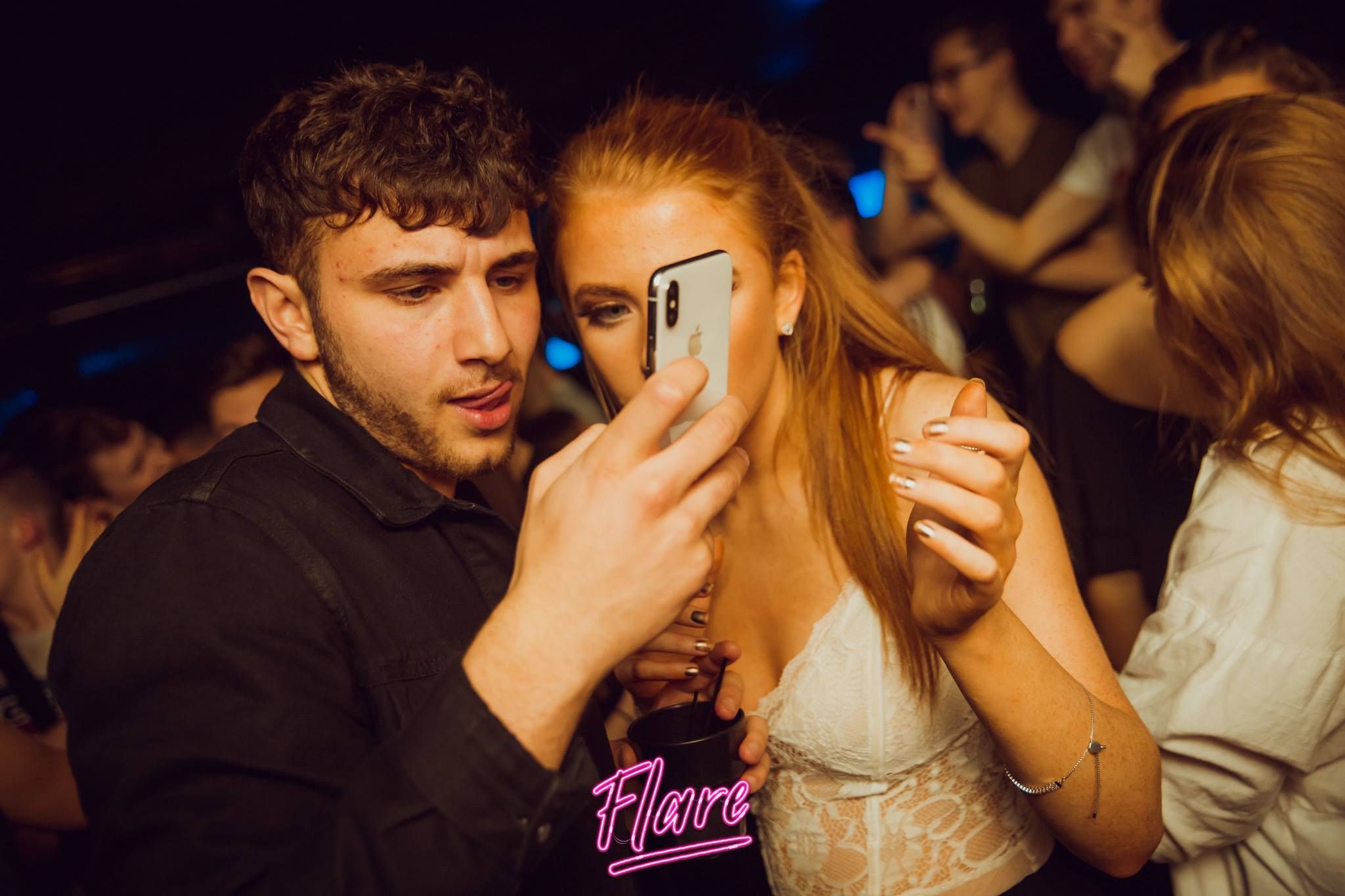 Image may contain: Night Club, Club, Electronics, Mobile Phone, Phone, Cell Phone, Night Life, Human, Person