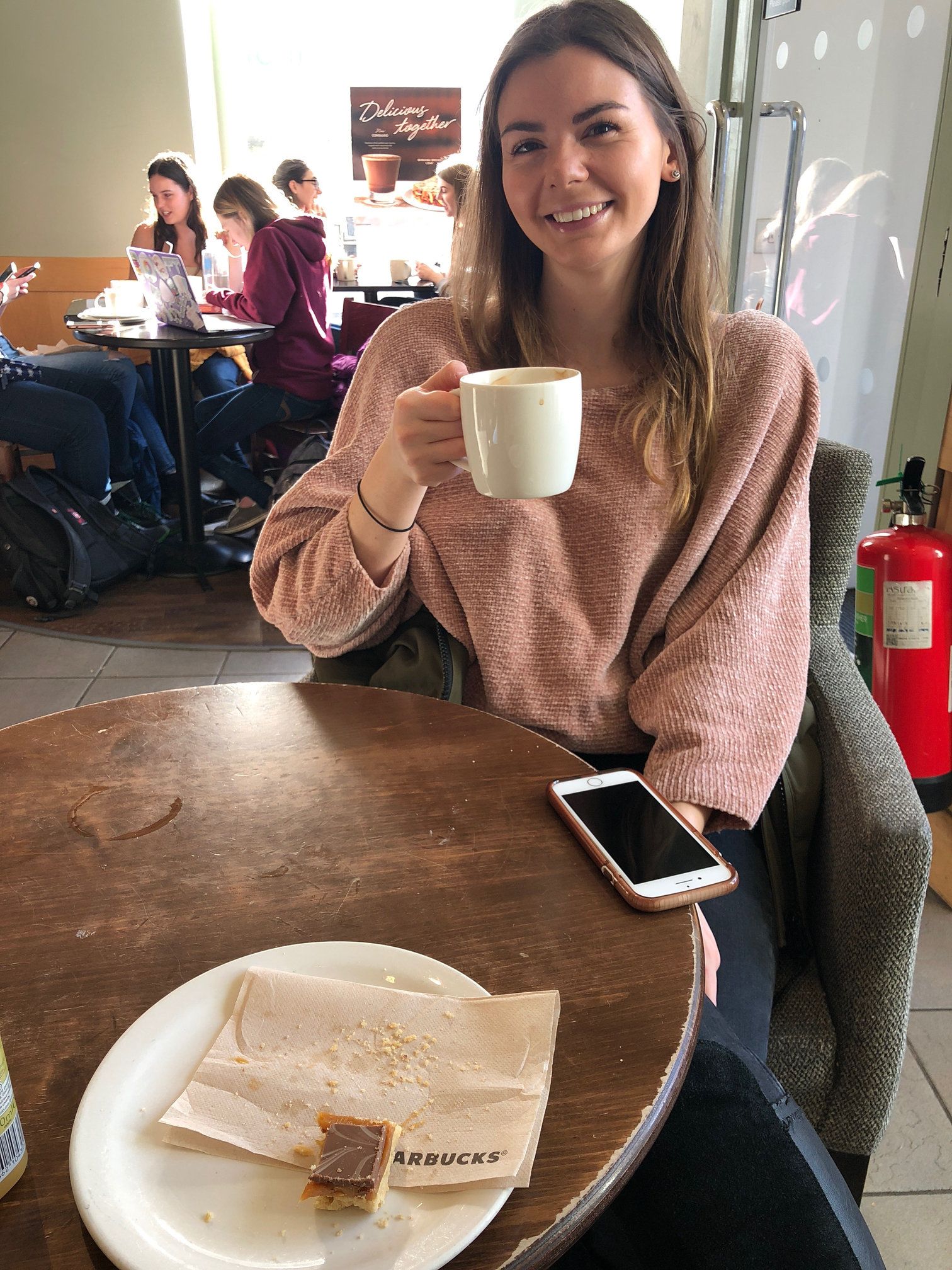 Image may contain: Coffee Cup, Cup, Cafeteria, Sitting, Cafe, Food, Food Court, Human, Person, Restaurant