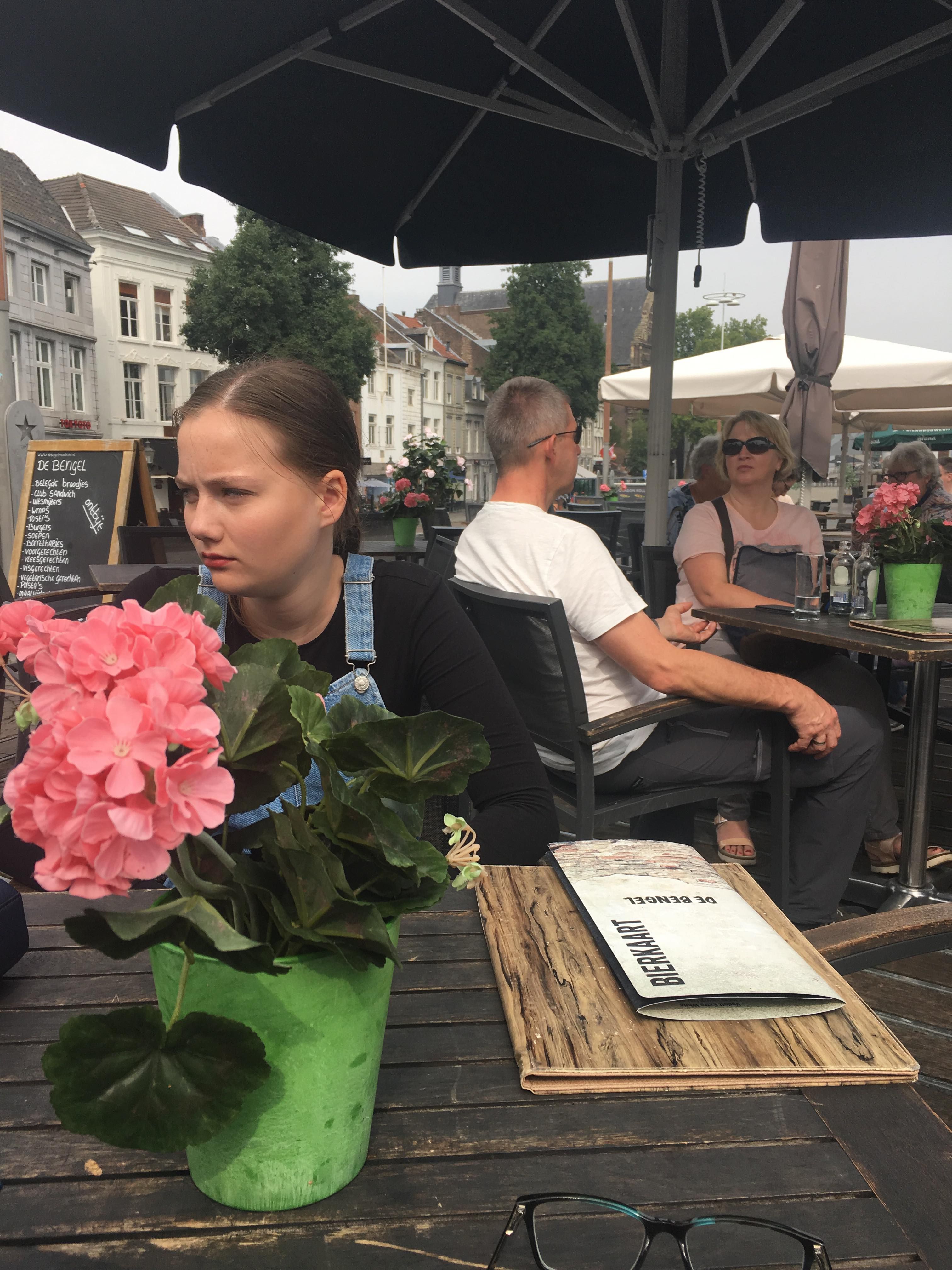 Image may contain: Cafe, Sitting, Restaurant, Geranium, Flower, Blossom, Plant, Accessory, Accessories, Sunglasses, Human, Person