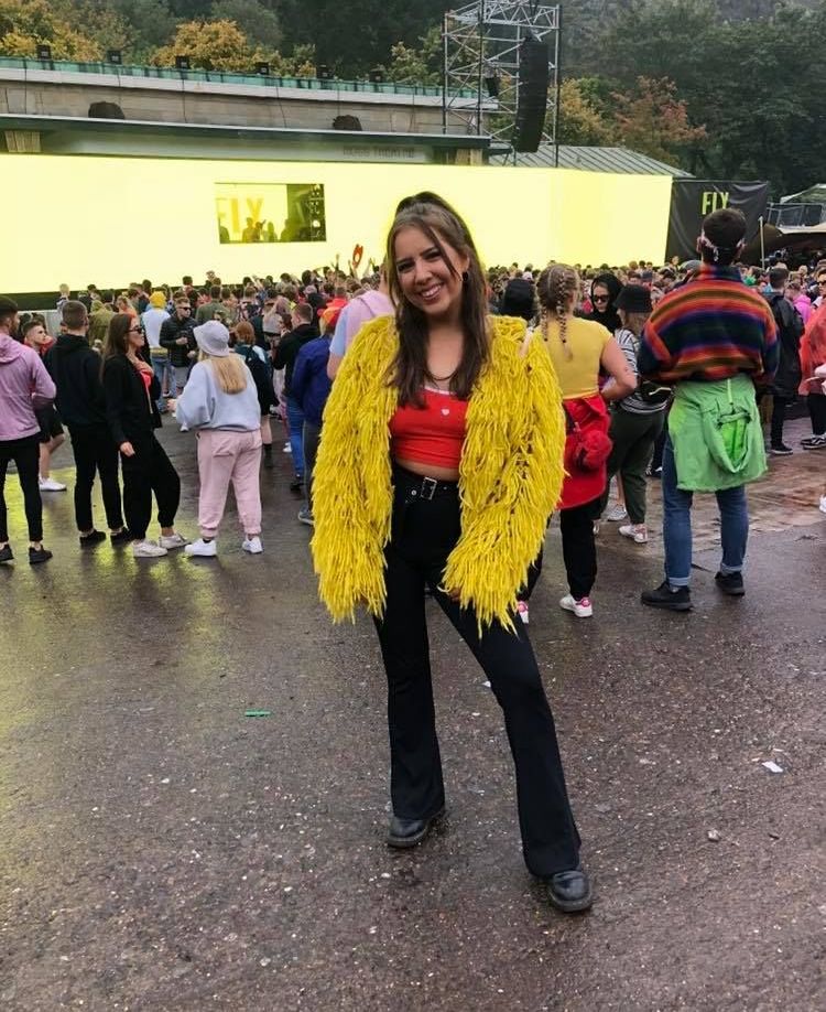 Image may contain: Coat, Smile, Photography, Photo, Portrait, Girl, People, Woman, Crowd, Pants, Female, Face, Costume, Human, Person, Footwear, Shoe, Apparel, Clothing