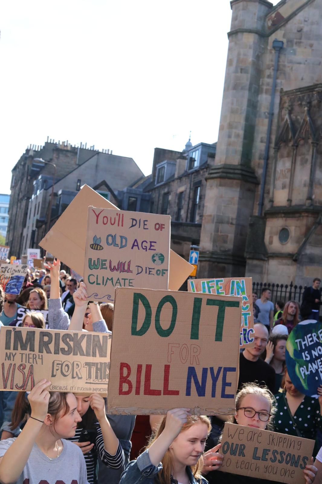 Image may contain: Crowd, Accessories, Glasses, Accessory, Banner, Text, Human, Person