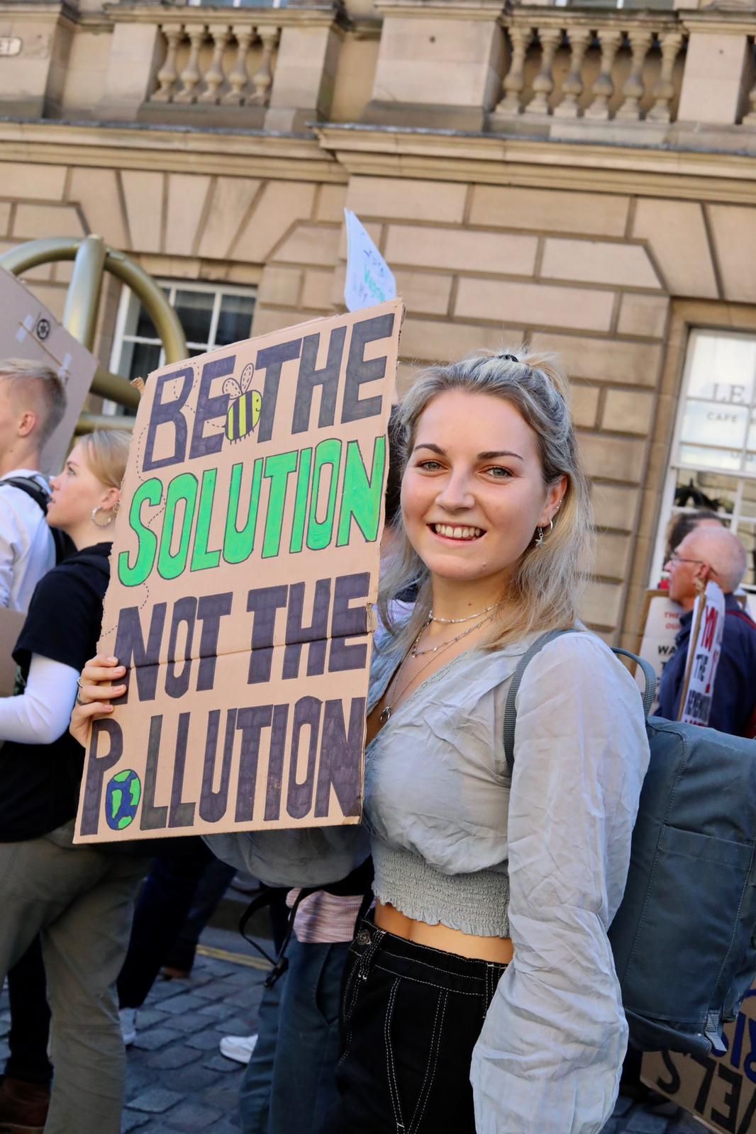 Image may contain: Word, Banner, Crowd, Footwear, Shoe, Clothing, Apparel, Text, Person, Human
