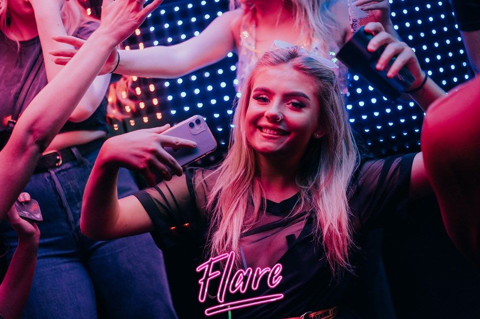 Image may contain: Phone, Electronics, Mobile Phone, Cell Phone, Party, Night Club, Night Life, Club, Person, Human