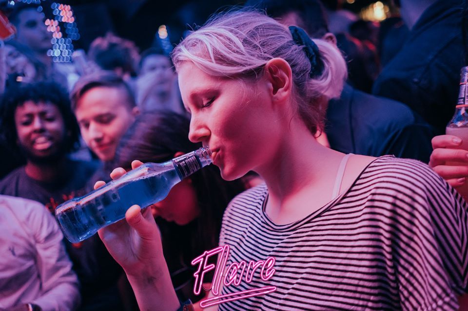 Image may contain: Drink, Beverage, Finger, Head, Audience, Party, Crowd, Guitar, Leisure Activities, Musical Instrument, Night Life, Human, Person