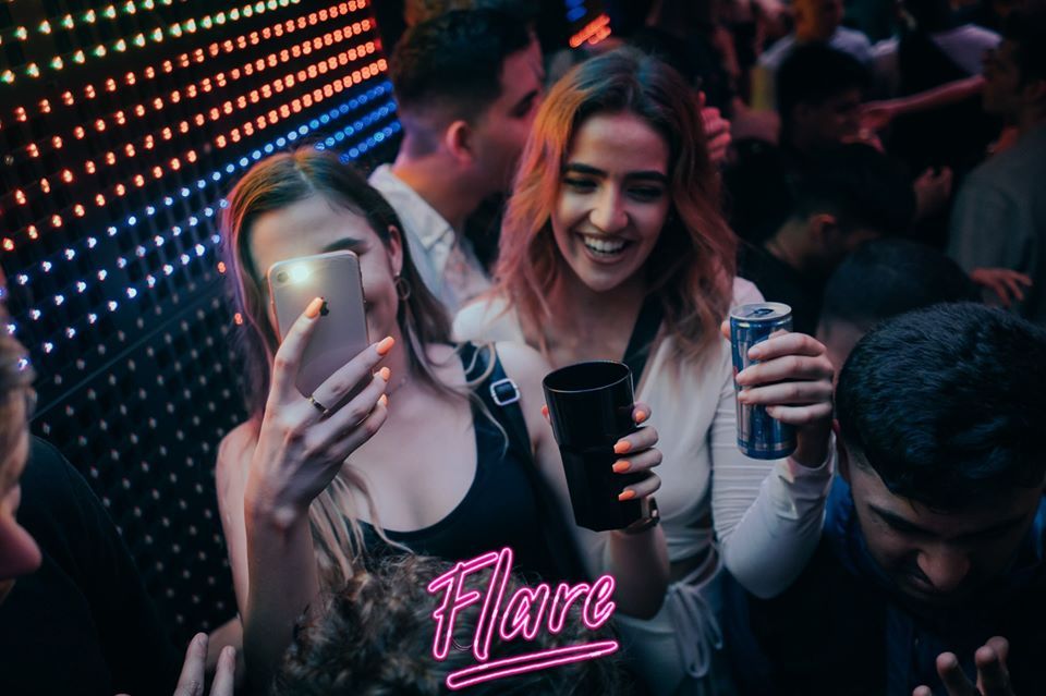 Image may contain: Night Club, Club, Night Life, Karaoke, Leisure Activities, Party, Cell Phone, Electronics, Mobile Phone, Phone, Human, Person
