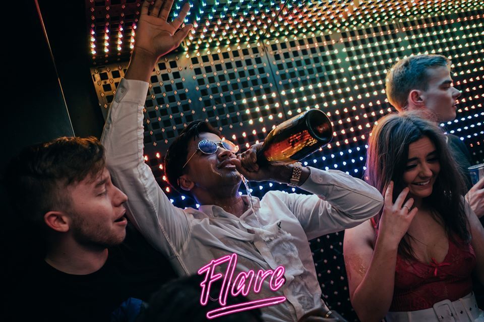 Image may contain: Night Life, Bottle, Bar Counter, Pub, Accessories, Sunglasses, Accessory, Beer, Alcohol, Beverage, Drink, Party, Person, Human