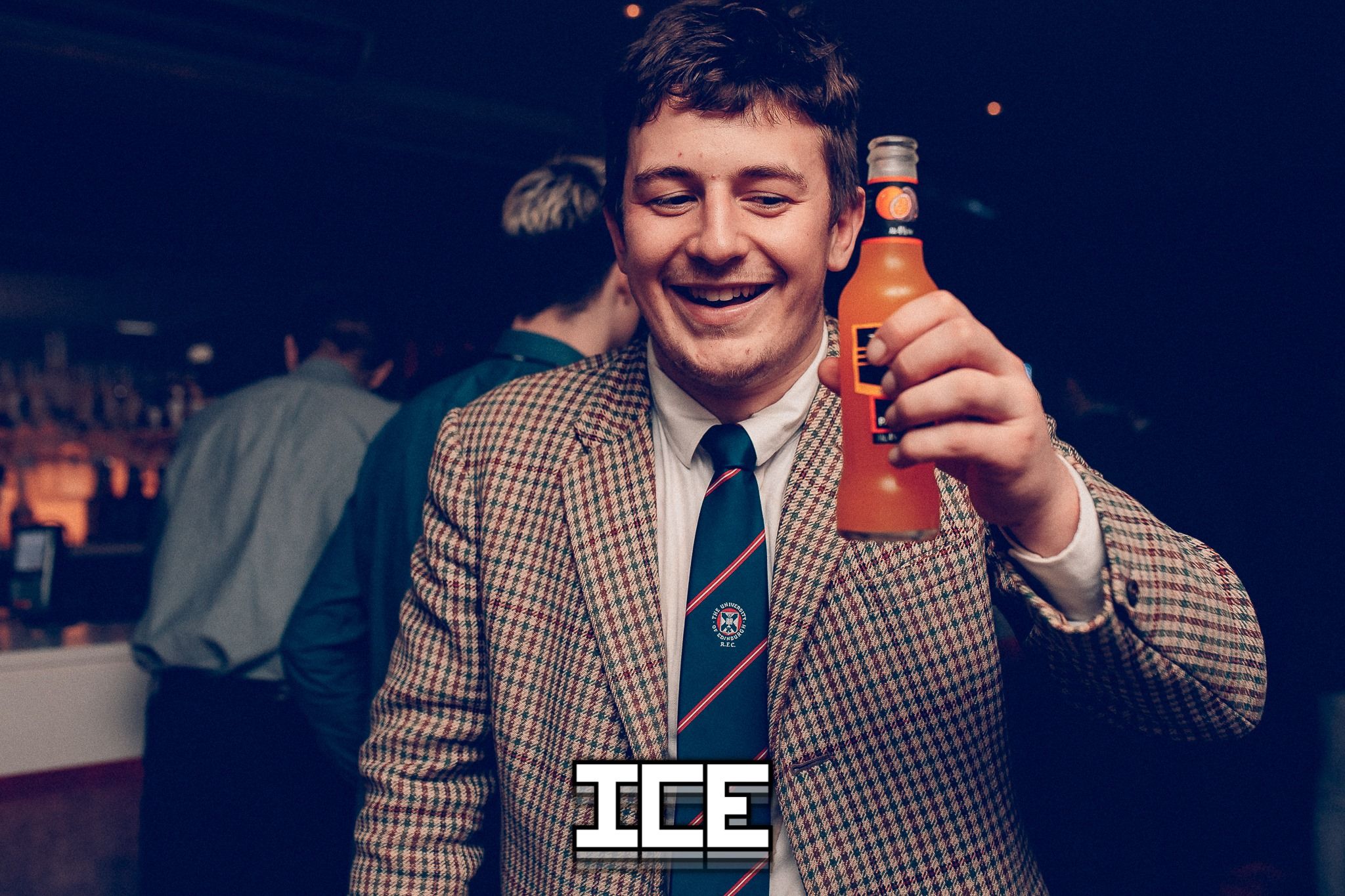 Image may contain: Club, Coat, Clothing, Apparel, Overcoat, Suit, Bar Counter, Beer Bottle, Pub, Drink, Alcohol, Beer, Beverage, Bottle, Person, Human, Accessories, Accessory, Tie