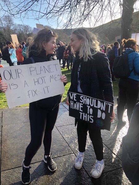 Image may contain: Vehicle, Transportation, People, Pants, Protest, Parade, Text, Apparel, Clothing, Crowd, Human, Person
