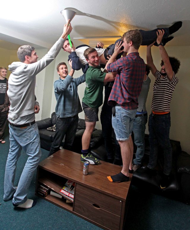 George Streets downs a beer bong whilst doing a 'Starfish' on the ceiling, at the Regent House in Plymouth, Devon. Regent house is the biggest student house in the UK, and is home to 32 students. See swns story SWSTUDENT - Home to 32 students, 22 toilets, a pool table, five fridges and seven showers, this is Britain's biggest student house. Situated in the heart of Plymouth's student suburb, Regent House is comprised of three large terrace town houses knocked into one. Made up of eight females and 24 males, the house needs three cleaners six days a week to keep on top of the mess. The students, which come from countries across the globe and are aged between 18 - 24, study subjects ranging from civil engineering, to fine art to business to midwifery. On average per week the students get through around 40 loo rolls, 20 bin bags of rubbish, 100 tins of baked beans and 500 cans of beer, 150 cans of cider, 50 Pot Noddles, 150 takeaways. Largely first years. Supposed to 320 hours a week at uni - each watch on average 42 hours a week TV (1,300 hours total) and play 28 hours Playstation each (a total of 900 (hours). Pay 75 - 100 per week